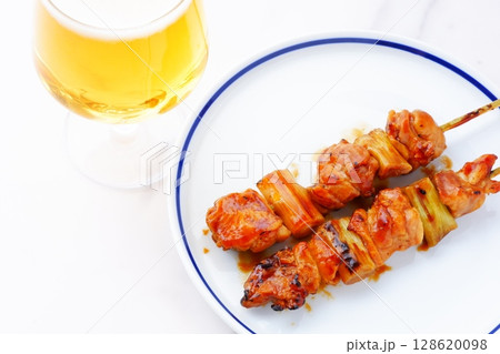 焼き鳥とビール - 炭火焼にしたタレの焼き鳥（ねぎま）をつまみにビールを飲む 128620098