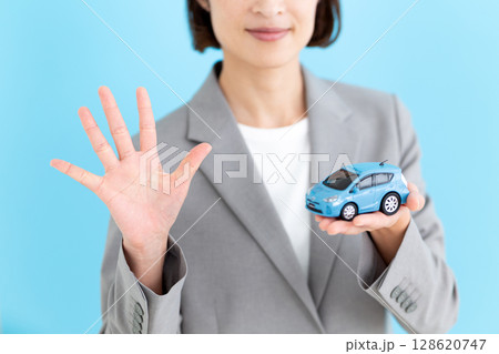 自動車の模型を持って5本指を立てるミドル女性ビジネスウーマン 自動車の模型を持って5本指を立てるミドル女性ビジネスウーマン 128620747
