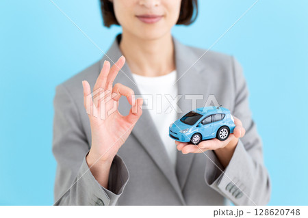 自動車の模型を持って丸サインをするミドル女性ビジネスウーマン 自動車の模型を持って丸サインをするミドル女性ビジネスウーマン 128620748