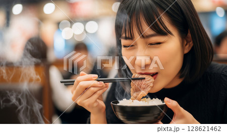 焼き肉とご飯を食べる女性 128621462
