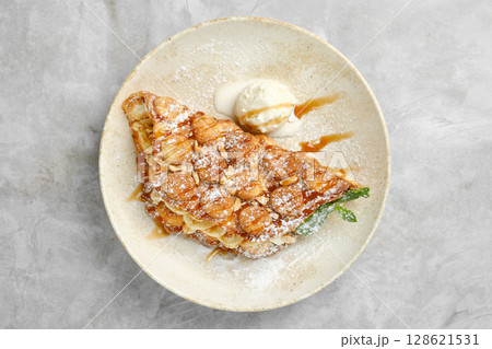 Delicious dessert featuring caramelized bananas and ice cream served on a plate 128621531