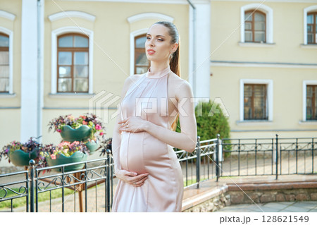 Expecting mother poses elegantly outside historic building in early morning light Expecting mother poses elegantly outside historic building in early morning light 128621549