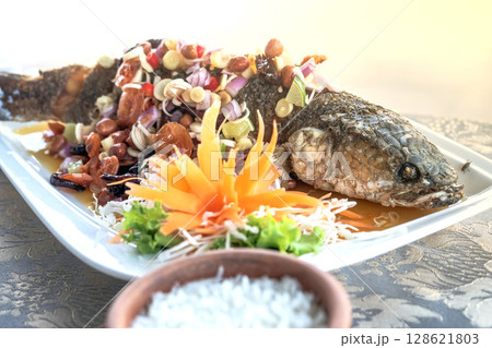 Fried Snakehead Fish in Spicy Herb Salad 128621803