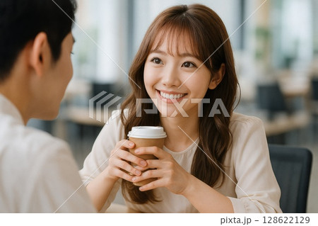 モダンなカフェで笑顔のアジア女性が男性と会話を楽しむ様子 モダンなカフェで笑顔のアジア女性が男性と会話を楽しむ様子 128622129