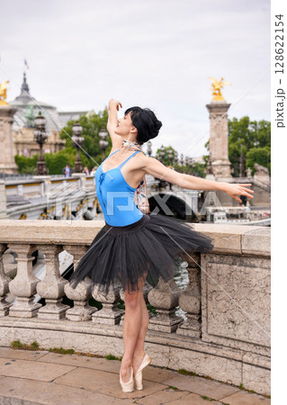 Ballerina in elegant pose on Pont Alexandre III bridge in Paris Ballerina in elegant pose on Pont Alexandre III bridge in Paris 128622154