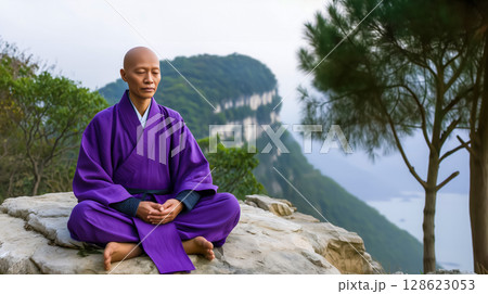 humanoid practicing meditation for the practice of self-awareness, a monk meditates on a rock above a chasm against the backdrop of the sea, Copy space about meditation aimed at achieving liberation 128623053