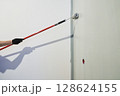 A man paints walls with a roller, working painting on the surface, painting walls in an apartment, repairing with white paint. With space to copy. High quality photo 128624155