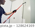 A professional paints the inside wall of his house. Apartment renovation. Concrete walls are painted gray with a paint roller. High quality photo 128624169