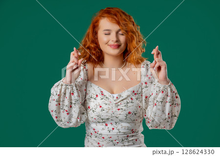 Woman praying with crossed fingers, green background. Lady begs someone, satisfy desires, help with, prays for luck. Woman praying with crossed fingers, green background. Lady begs someone, satisfy desires, help with, prays for luck. 128624330