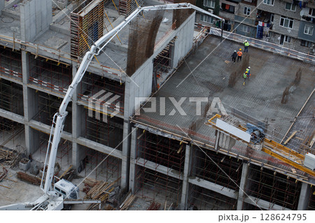 Construction Spider Crane Working on a High-Rise Building Using Machinery and Scaffolding Construction Spider Crane Working on a High-Rise Building Using Machinery and Scaffolding 128624795