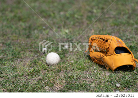 球場に置いてあるグローブ 球場に置いてあるグローブ 128625013