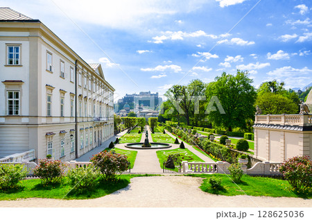 Mirabell gardens, looking toward Hohensalzburg Fortress, popular tourist attraction in Salzburg City, Austria. Mirabell Castle on the right, Pegasus fountain in the center, the historic city behind. Mirabell gardens, looking toward Hohensalzburg Fortress, popular tourist attraction in Salzburg City, Austria. Mirabell Castle on the right, Pegasus fountain in the center, the historic city behind. 128625036