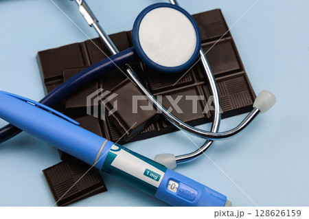 Insulin injection pen and dark chocolate for diabetics and weight loss. 128626159