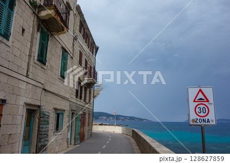 ancient beachfront stone buildings in Komiza municipality, on the island of Vis in Adriatic Sea, Croatia ancient beachfront stone buildings in Komiza municipality, on the island of Vis in Adriatic Sea, Croatia 128627859