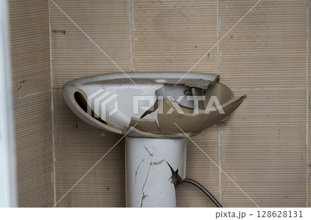 The broken washbasin of an outdoor toilet 128628131