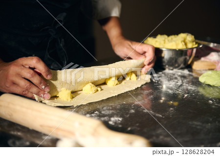 Chef Crafting Fresh Dough in a Cozy Kitchen Environment Depicting Culinary Art and Tradition Chef Crafting Fresh Dough in a Cozy Kitchen Environment Depicting Culinary Art and Tradition 128628204