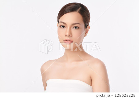 A beautiful young Asian woman with clean, fresh skin against a white background. Skincare, facial treatment, cosmetology, beauty, and spa. An elegant portrait of an Asian woman. 128628229