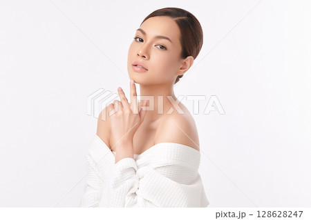 A beautiful young Asian woman with clean, fresh skin against a white background. Skincare, facial treatment, cosmetology, beauty, and spa. An elegant portrait of an Asian woman. 128628247