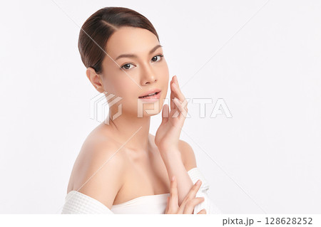 A beautiful young Asian woman with clean, fresh skin against a white background. Skincare, facial treatment, cosmetology, beauty, and spa. An elegant portrait of an Asian woman. 128628252