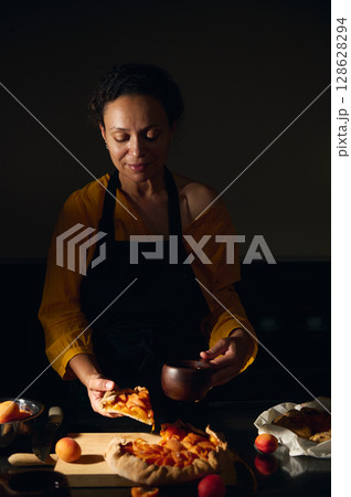 Woman Prepares Homemade Fruit Tart in a Cozy Kitchen Setting 128628294