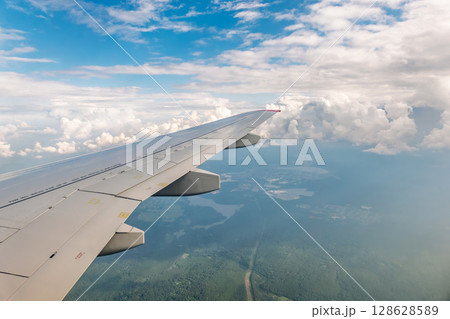 View from the airplane window at a beautiful cloudy sky and the airplane wing 128628589