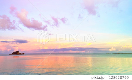 幻想的な南国のサンセット、静かな海と夕暮れ空の絶景、水平線と雲のグラデーション 沖縄平安座島 128628799
