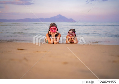 Sisters enjoying a magical evening at the beach with snorkeling gear Sisters enjoying a magical evening at the beach with snorkeling gear 128629455