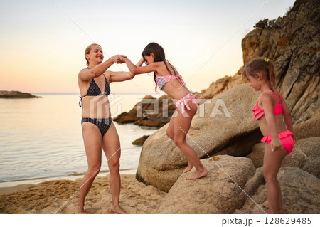Joyful family retreat at the beach during a tranquil sunset Joyful family retreat at the beach during a tranquil sunset 128629485