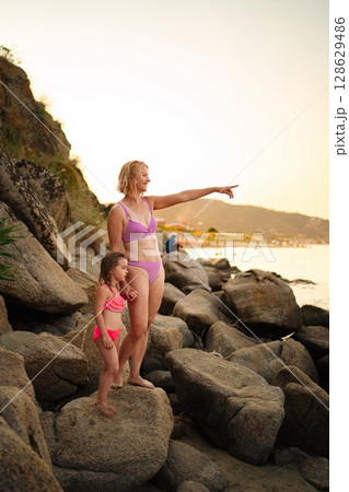 Family enjoys a seaside adventure on a sunny day at the beach Family enjoys a seaside adventure on a sunny day at the beach 128629486