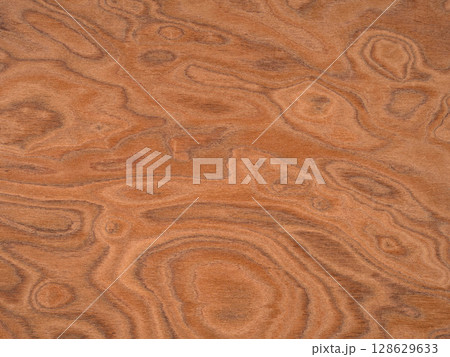Elm burl veneer surface with a mesmerizing array of cinnamon swirls and deep amber accents 128629633