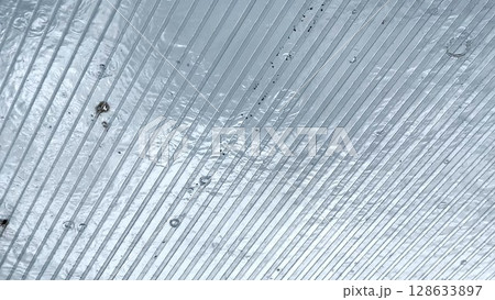 Heavy rain drumming on the transparent plexiglass roof. Beautiful rainy scene on summer day. Concept of tranquility nature scene. Close up Slow motion 128633897