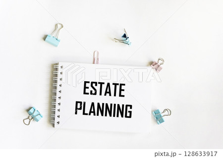 A notebook with the text Real estate planning. Paper clips on a white background. Business concept 128633917