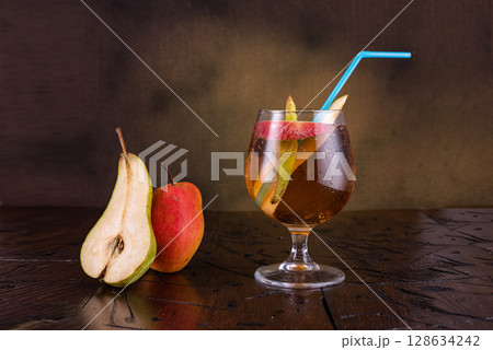 Fresh fruit drink. Pear lemonade. Pear drink in a glass. Glass glass with a straw. Pear slices near the glass. 128634242