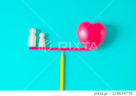 Wooden figure standing balance with red heart sign. Wooden figure standing balance with red heart sign. 128634776