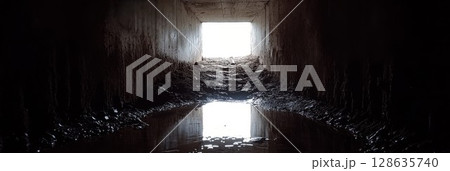 Dark Urban Tunnel Mysterious Light Concrete Water Reflection wet old way city damp worn path exit Dark Urban Tunnel Mysterious Light Concrete Water Reflection wet old way city damp worn path exit 128635740