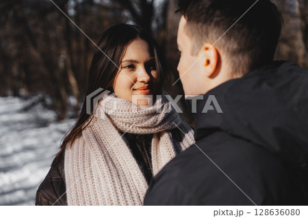 Couple enjoying a winter day while sharing a tender moment in nature Couple enjoying a winter day while sharing a tender moment in nature 128636080