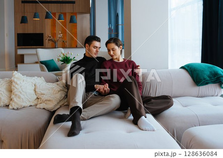 Couple enjoying a cozy moment together in a modern living room setting 128636084