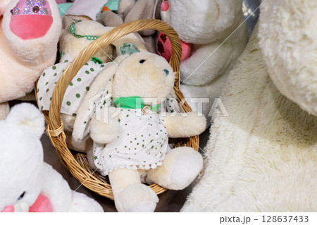 A basket filled with stuffed animals, including a bunny dressed A basket filled with stuffed animals, including a bunny dressed 128637433