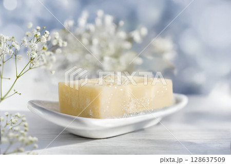 Beautiful Natural Soap Bar on a White ceramic soap dish Surrounded by Charming Floral Accents 128637509