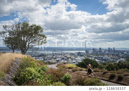 Man jogging in nature park with coastal city skyline in backdrop, Auckland, New Zealand Man jogging in nature park with coastal city skyline in backdrop, Auckland, New Zealand 128638337