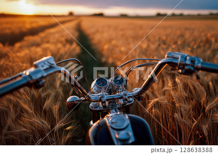 A motorcycle is in the foreground of a field of wheat 128638388
