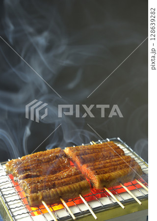 煙り立ち昇る七輪で鰻の蒲焼 煙り立ち昇る七輪で鰻の蒲焼 128639282