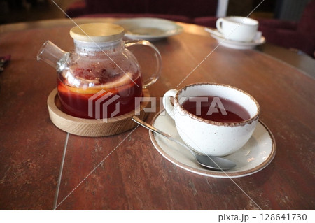 Enjoy a delightful tea time with brewed herbal tea served in a beautiful teapot 128641730