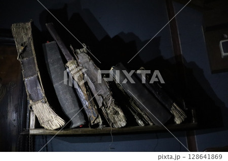 A Stunning Collection of Weathered and Antique Books Artfully Displayed upon a Dark Shelf A Stunning Collection of Weathered and Antique Books Artfully Displayed upon a Dark Shelf 128641869