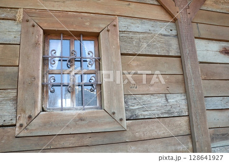 A Rustic Window adorned with Decorative Iron Bars set against a Wood Wall background panel A Rustic Window adorned with Decorative Iron Bars set against a Wood Wall background panel 128641927