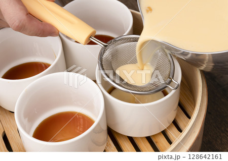 せいろで蒸すプリン　蒸しプリン　卵液を茶こしで濾して型に流し込む 128642161