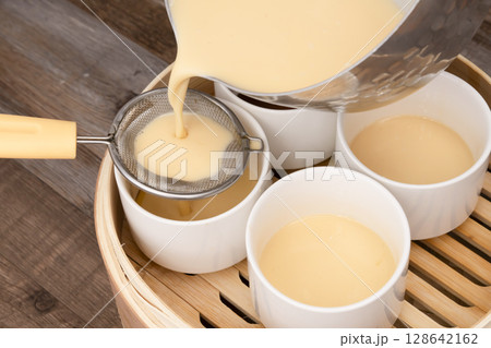 せいろで蒸すプリン　蒸しプリン　卵液を茶こしで濾して型に流し込む 128642162