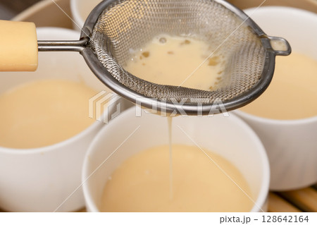 せいろで蒸すプリン　蒸しプリン　卵液を茶こしで濾して型に流し込む 128642164