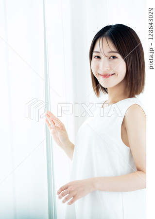 窓際に立つ女性 窓際に立つ女性 128643029