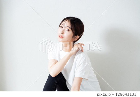 床に座る若い女性のポートレート 128643133